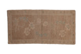 Vintage distressed Oushak rug mat with sprawling floral blossoms in muted sand and celadon green tones.