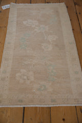 A distressed Oushak mat runner seen from an angle, showing its soft, even wear.