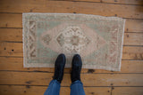 Distressed Oushak mat runner with faded celadon and pale copper abrashed field.