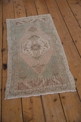 Muted celadon and pale copper medallion on a distressed vintage Oushak rug.