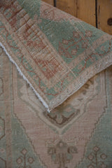 Distressed pile texture of vintage Oushak rug with cream, celadon green, and pale copper.