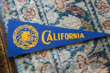 Blue felt University of California pennant, featuring yellow school crest and bold lettering.
