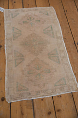 Angled view of a distressed vintage Oushak mat, showing the texture of its even wear.