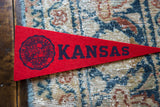 Vintage red felt University of Kansas pennant with dark blue school crest.