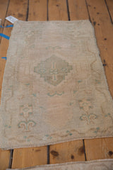 Distressed Oushak rug mat with even wear, displaying muted cream and celadon green patterns.