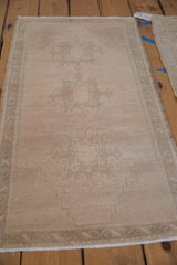 Even wear across the low pile of a distressed Oushak runner with a faint medallion pattern.