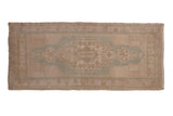 Vintage distressed Oushak rug runner featuring a faded seafoam green medallion on neutral tones, 1'7