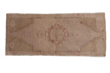 Distressed Oushak rug with faded cream, roundel medallion, and pale cranberry motifs.