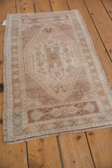 Neutral-toned vintage Oushak rug, highlighting distressed texture and even pile wear.