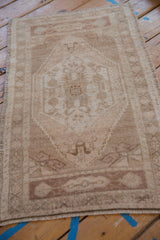 Distressed Oushak rug corner with original selvage, fringe, and ram's horn relief.