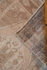Distressed beige Oushak rug pile texture with visible hand-knotted reverse and intact selvage.