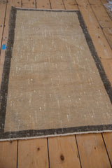 Distressed Oushak runner side with time-softened greige border and intact selvage.