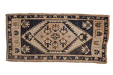 Distressed vintage Oushak rug with hexagonal medallion, dusty navy, ivory, and bronze tones.