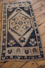 Distressed hexagonal medallion and finned germinating buds of a vintage Oushak rug.