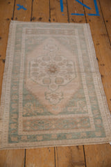 Evenly worn ivory and cream Oushak rug with faded seafoam green medallion motifs.