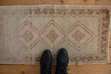 Distressed Oushak rug with faded triple diamond medallions and vine and blossom border.