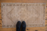 Vintage distressed Oushak rug mat showing diamond medallion, abrashed field, and even wear.