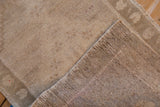 Worn beige pile of distressed vintage Oushak rug with faint foundation.