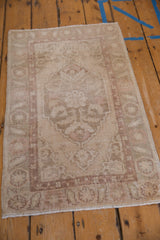 Distressed Oushak rug featuring even wear across knot heads in cream and pale rose.