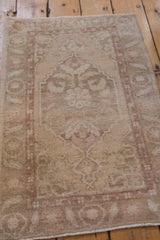 Subtle cream and pale rose scrolling leaves on a distressed Oushak rug mat.