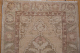 Detail of the distressed pile texture, faint scrolling motifs, and intact side selvage.