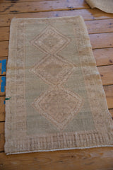 Distressed Oushak rug pile with even wear, original side selvage, and faint seafoam green.