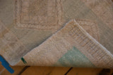 Vintage distressed Oushak rug with seafoam green foundation, original selvage, and worn pile.
