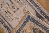 Distressed Oushak rug corner with dusty navy border, short pile, and intact selvage.