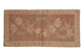 Vintage distressed Oushak rug with a floral spray in dusty mauve, sand, and seafoam green.