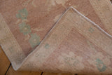 The hand-knotted back and intact side cord of a vintage distressed Turkish Oushak rug mat.