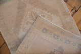 Vintage Oushak rug's woven foundation with faded seafoam green geometric pattern and intact side selvage.
