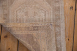 Oushak rug corner revealing distressed pile, foundation weave, and intact cord selvage.