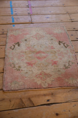 Distressed Oushak rug corner with worn pile, visible foundation, original side cord, and kilim end.