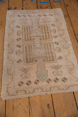 Distressed Oushak rug corner, revealing worn pile, faint foundation, and intact selvage.