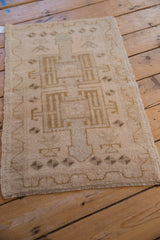 Distressed Oushak rug corner showing intact selvage, meandering vine border, and pale pile.