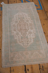 Lozenge medallion and geometric vinery on a distressed Turkish Oushak rug, seafoam green, ivory, sand.