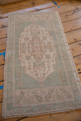 Distressed Oushak rug corner, highlighting even wear on dusty seafoam green and ivory.