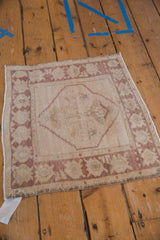 Corner of a vintage distressed Oushak rug, highlighting palmette border design and worn texture.