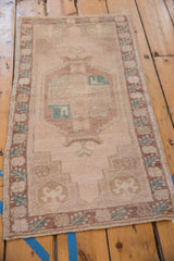 Vintage distressed Oushak runner showing faint foundation, muted stepped geometric pattern.