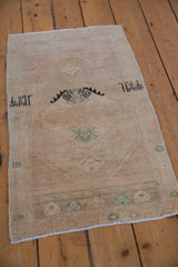 Distressed vintage Oushak rug mat with faded motifs in ivory, sand, and seafoam green.