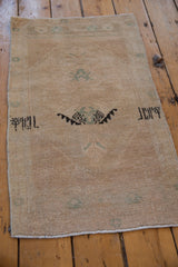 Distressed Oushak rug center with serrated lightning medallion in beige, seafoam green, charcoal.