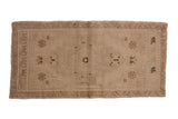Distressed vintage Oushak hand knotted rug with faded medallion and floral designs in beige and brown.