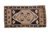 Distressed vintage Oushak rug with faded ivory medallion and navy ground, 1'9