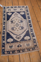 Vintage distressed Oushak rug, central primitive palmettes with serrated navy and ivory outline.