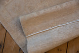 Intact side cord selvage and hand-knotted foundation of the distressed beige Oushak runner.