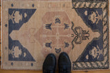 Vintage Oushak rug mat in dusty blue and sandalwood shown on the floor for scale.