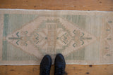 Distressed Oushak rug runner with central lightning medallion, softened cream and seafoam.
