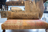 Antique Persian fragment pillow showing worn texture, visible foundation, and early 20th century pattern.
