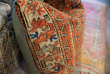 Detail of vintage Persian pillow showing rust coral geometric pattern and seafoam green linen backing.