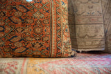 Textured vintage Persian fragment pillow in rust coral, seafoam green, and blue.